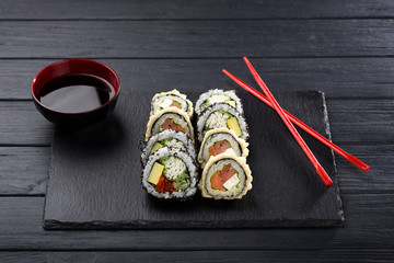 Sushi set. maki, gunkan and sushi rolls served on stone slate. Sushi set on a stone plate and dark concrete background. Sushi roll set and chopsticks. Fresh Japanese cuisine. asian food. Sushi image f