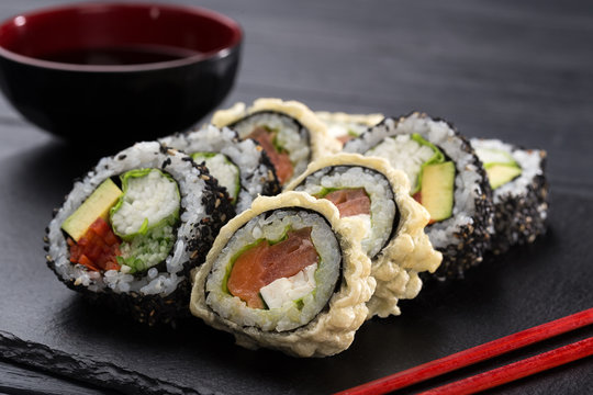 Sushi set. maki, gunkan and sushi rolls served on stone slate. Sushi set on a stone plate and dark concrete background. Sushi roll set and chopsticks. Fresh Japanese cuisine. asian food. Sushi image f