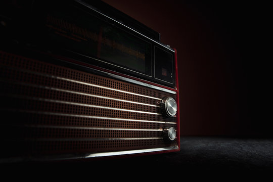 Red radio on dark background. Close up of old retro things shooted with vintage style colors and toned. Flyer for your ad. Concept of retro style, history return, fashioned things, hobby, memories. - Powered by Adobe