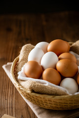 Chicken eggs in basket on table.