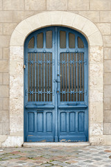 Fototapeta na wymiar Old wooden door in typical blue color, entrance to the medieval house in historic part of Chartres, France
