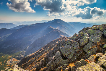Mountainous landscape with hills and valleys at a sunny day in autumn season.  Dumbier, the highest peak of the Low Tatras National Park in background, Slovakia, Europe