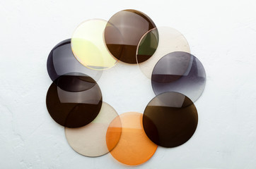 Closeup of optical colorful lenses that made a shape of circle on the white surface