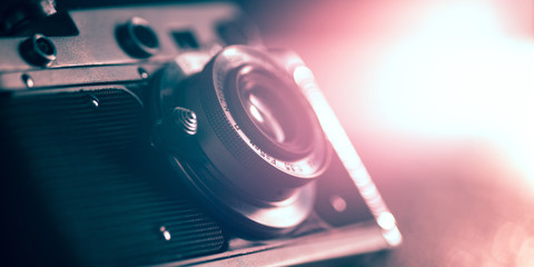 Photo camera on dark background. Close up of old retro things shooted with vintage style colors and toned. Flyer for your ad. Concept of retro style, history return, fashioned things, hobby, memories.