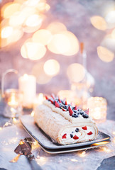 Meringue roll cake with cream and fresh berries