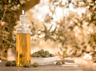 green olives and oil on table in olive grove