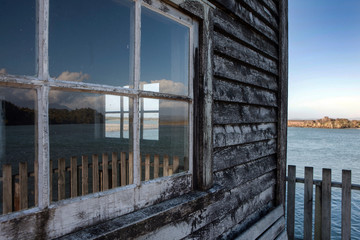 Okarita South island coast. New Zealand. Historic Jetty. Wooden shed. Window