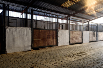 Empty stable with dirty wooden doors on a farm.