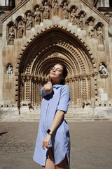 Fototapeta na wymiar Traveller blond woman in front of The Chapel of Jak in Vajdahunyad Castle in the City Park in Budapest, Hungary.