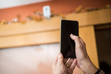 Controlling surveillance camera at home from the mobile phone. Home security concept at home