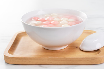 Tang yuan, tangyuan, delicious red and white rice dumpling balls in a small bowl. Asian traditional festive food for Chinese Winter Solstice Festival, close up.
