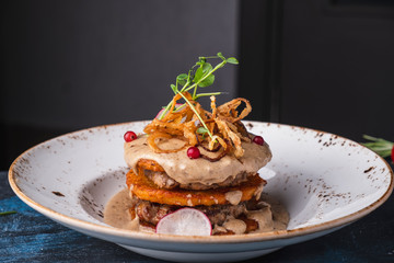 Potato pancakes and meat cutlet with sauce.