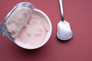 top view of yogurt in a container on red background 