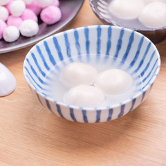 Fototapeta na wymiar Tang yuan, tangyuan, yuanxiao in a small bowl. Delicious asian traditional festive food rice dumpling balls with stuffed fillings for Chinese Lantern Festival, close up.