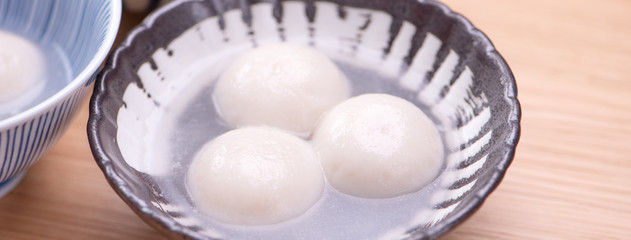 Tang yuan, tangyuan, yuanxiao in a small bowl. Delicious asian traditional festive food rice dumpling balls with stuffed fillings for Chinese Lantern Festival, close up.