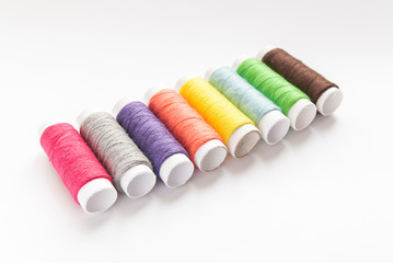 colorful spools of thread close-up on a white background
