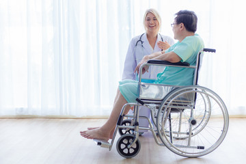 Fototapeta na wymiar Nurse reassuring her patient on wheelchair in hospital / healthcare medical concept. copy space