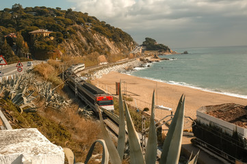 View from the highway to the train passing by rail and the Mediterranean Sea in Catalonia, Spain