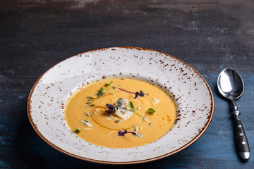 Delicious pumpkin soup with blue cheese. Pumpkin soup served with spoon. Copy space