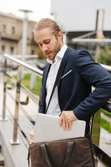 Handsome young bearded businessman standing outdoors