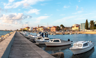 Small Dalmatian town of Biograd Na moru , Croatia. View of the sea and local small boats in marina. Sunny cloudy day