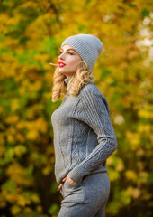 Woman enjoy autumn season in park. Warm knitwear. Feel practicality and comfort. Model knitwear clothes leaves background. Girl relaxing in nature wearing knitwear suit. Clothes for rest. Sporty girl