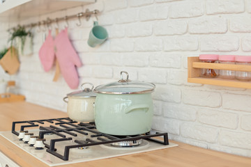 Modern kitchen wit white wall and pots on strove.