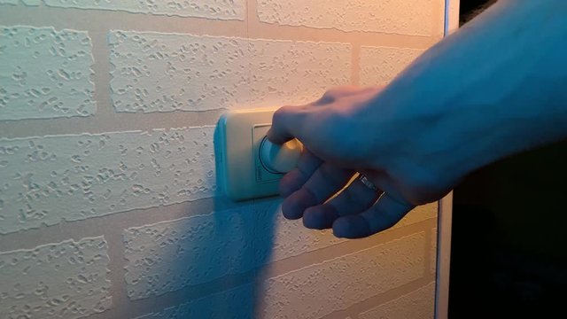 Male hand close-up rotates dimmer switch the light switch