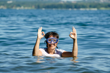 Woman with Diving Mask in the Water and Showing the OK Signal.