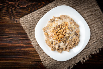 Oatmeal with honey, yogurt and peanut on dark wooden background.