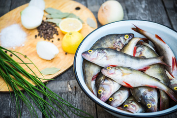 Raw fish. Fish prepared for cooking. Perch and spices on a wooden table.