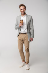 Portrait of smiling handsome man posing with laptop and paper cup