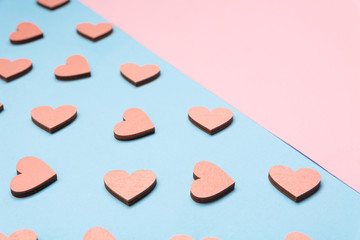 Pink and blue background. Pink wooden hearts on a blue background
