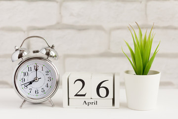 April 26 on a wooden calendar next to the alarm clock.Calendar date, holiday event, or birthday