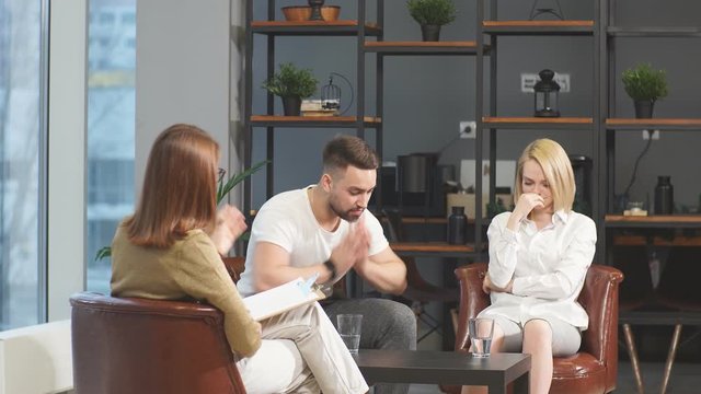 Married couple arguing and quarreling during visit professional psychologist and marriage counselor office. Psychological help and people concept.