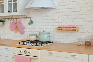 Modern kitchen wit white wall and pots on strove.