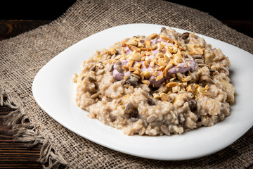 Oatmeal with honey, yogurt and peanut on dark wooden background.