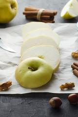 Sliced green apple with honey and nuts on crumpled paper
