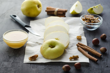 Sliced green apple with honey and nuts on crumpled paper