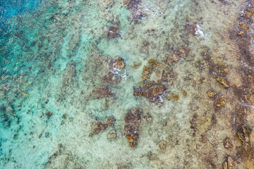 Aerial view of coast of Curaçao in the Caribbean Sea with turquoise water, cliff, beach and beautiful coral reef over Tugboat Beach
