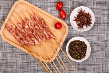 Fresh slices of raw mutton are strung with bamboo sticks and placed on plates