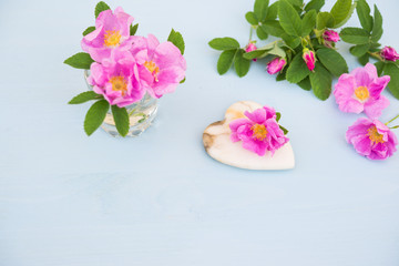 Rose. Pink flower with Heart of marble on an blue wooden table. Valentine background