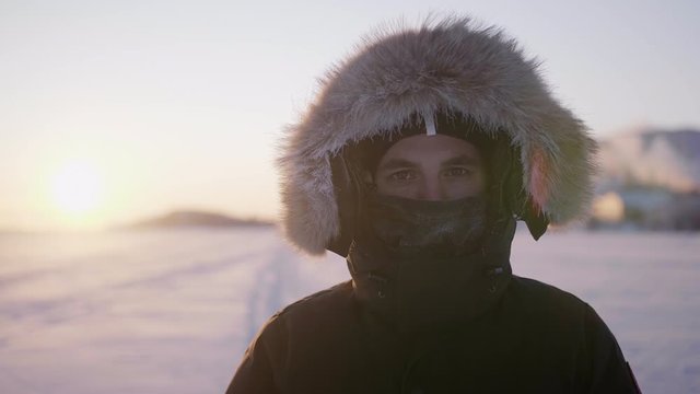 Close up portrait of middle aged explorer in hood and buff in winter