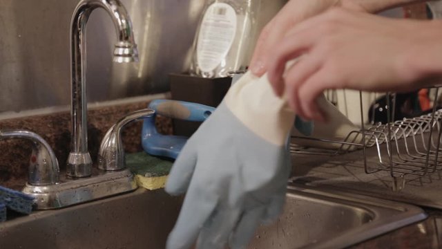 Removing Off The Wet Gloves And Hanging Them On The Dish Rack - Close Up Shot