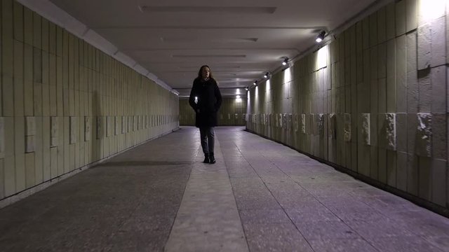 Girl standing in the underground passage at night