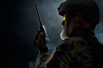 Military officer holding radio station.