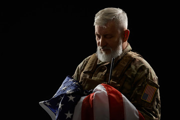 Military veteran holding american flag.