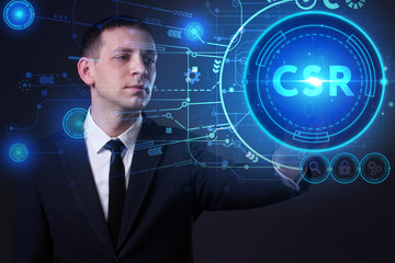Business, Technology, Internet and network concept. Young businessman working on a virtual screen of the future and sees the inscription: CSR