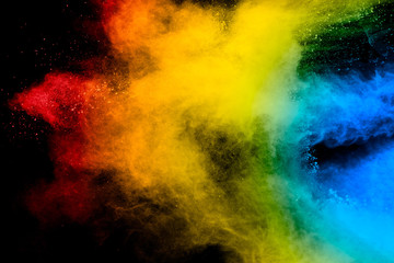 Freeze motion of colored powder explosions isolated on black background.Color dust particle splatter on background.