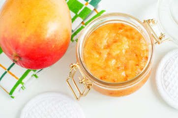 Homemade mango facial mask (exfoliating face and body sugar scrub) in the glass jar. Fruit DIY...